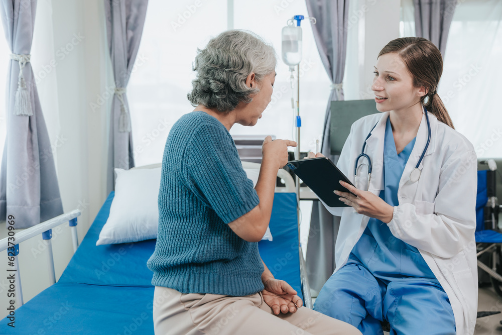 Fototapeta premium Beautiful modern female doctor talking to an elderly woman patient with a smiling face at the hospital.