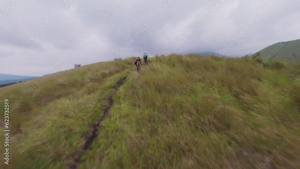 Enduro motorbike riders group driving tour on mountain ridge enjoy freedom travel adventure aerial view. FPV sport drone shot motorcycle cross adrenaline extreme journey autumn terrain cloudy valley Enduro motorbike riders group driving tour on mountain ridge enjoy freedom travel adventure aerial view. FPV sport drone shot motorcycle cross adrenaline extreme journey autumn terrain cloudy valley