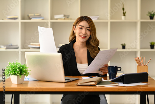 Gorgeous asian female company worker or manager using laptop and working with financial document Free Download Gorgeous asian female company worker or manager using laptop and working with financial document - GFXLoad