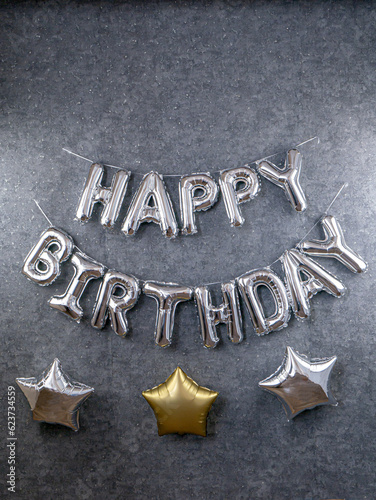 Photography Silver inscription happy birthday and big stars on a gray wall