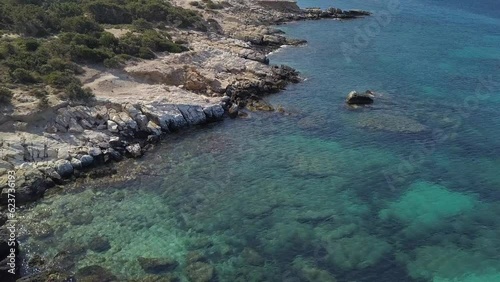 4K Drone footage - Aerial view of a stunning bay with turquoise blue water and rocks on Naxos near Alyco - Greece