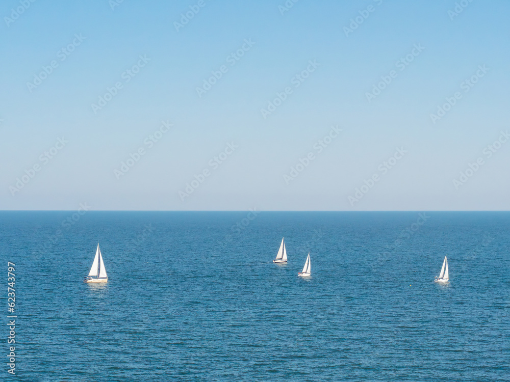 Sailing boat yacht or sailboat group regatta race on sea or ocean water. 