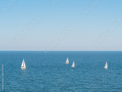 Sailing boat yacht or sailboat group regatta race on sea or ocean water. 