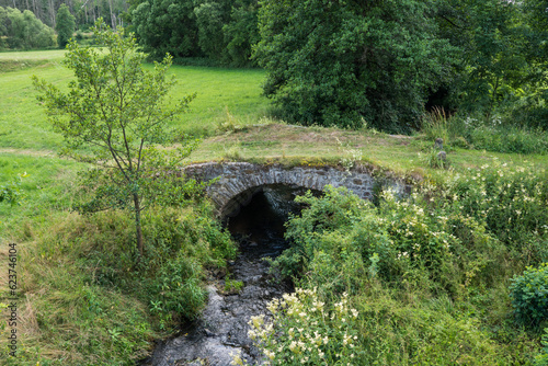 Old stone bridge in the middle of meadows
