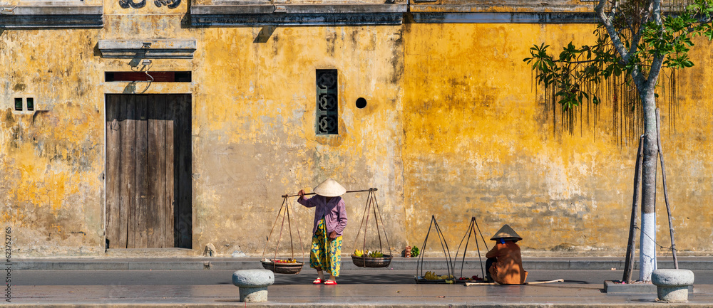 Unidentified Vietnamese merchants wearing traditional Vietnamese style conical hat