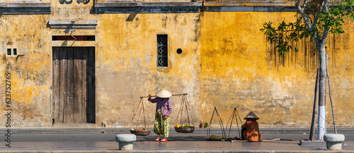 Unidentified Vietnamese merchants wearing traditional Vietnamese style conical hat "non la" at Hoi An, Vietnam.