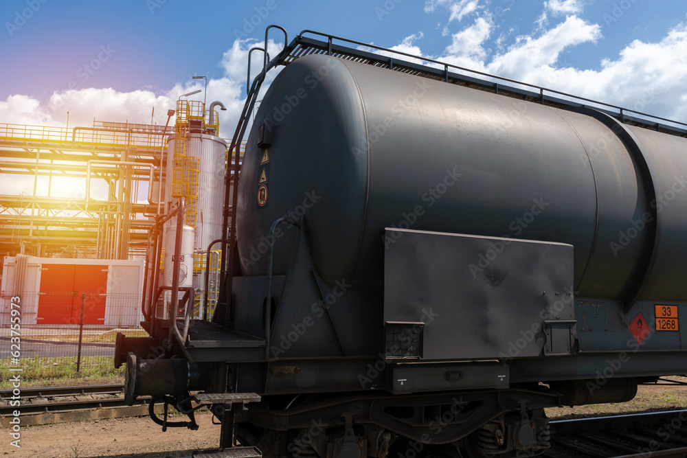 Naklejka premium Railroad tank cars near oil refinery. Railway train wagon to transport liquid and gaseous commodities. Industrial zone equipment.