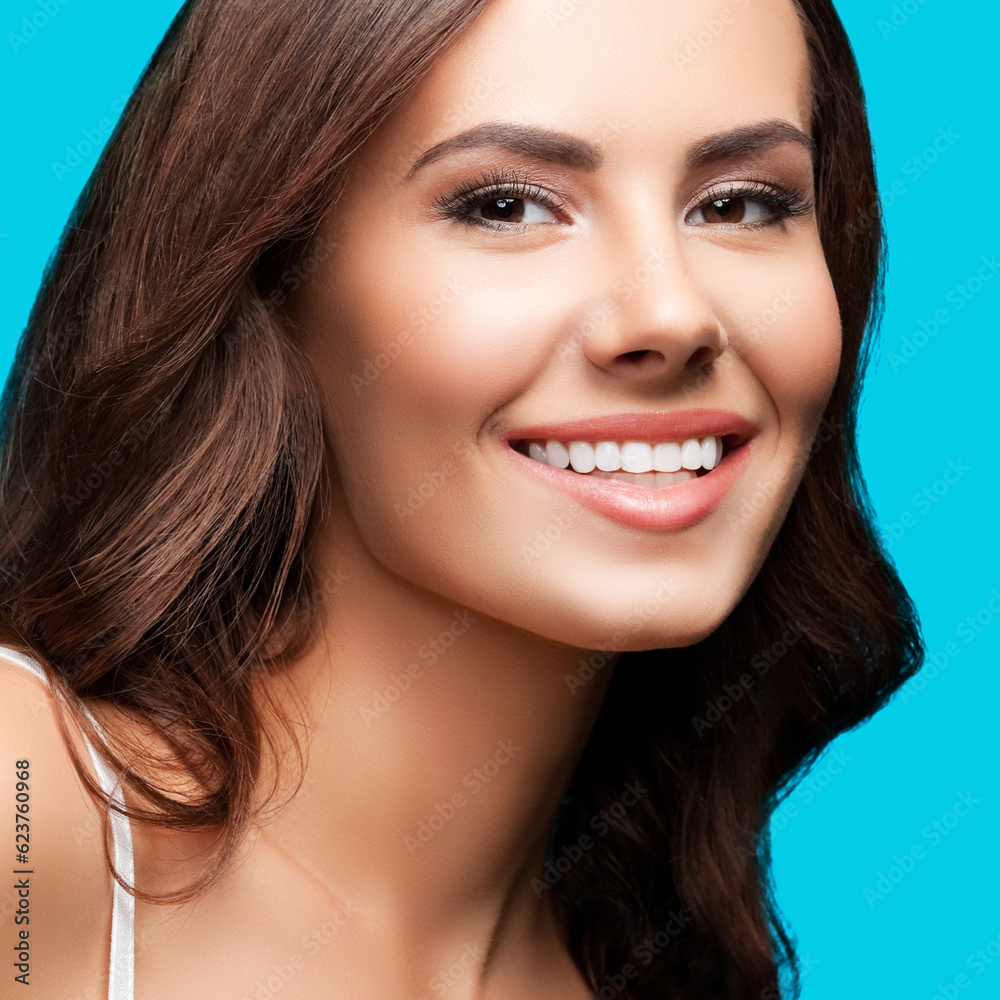 Portrait of smiling beautiful woman in white casual tank top, over aqua blue green background. Brunette girl at studio concept. Square composition. Portrait of smiling beautiful woman in white casual tank top, over aqua blue green background. Brunette girl at studio concept. Square composition.