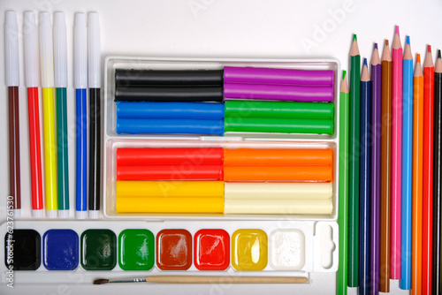 Children, school set for creativity and drawing from colored pencils, watercolor paints, felt tip pens and plasticine.