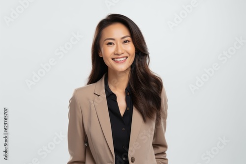 Portrait of a beautiful young asian businesswoman smiling over white background