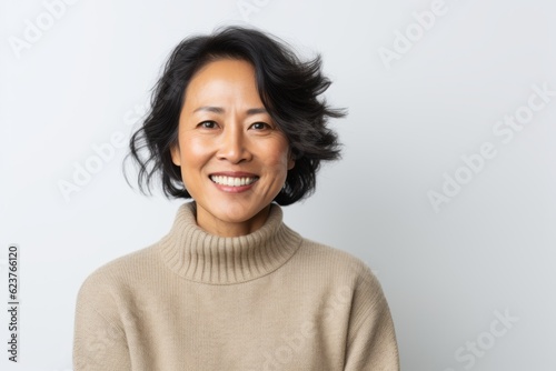 Portrait of smiling asian woman looking at camera over white background