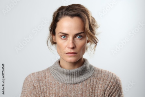 Portrait of a serious young woman in sweater looking at camera.