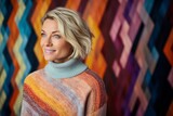 Portrait of smiling woman in sweater against colourful wall in room at home