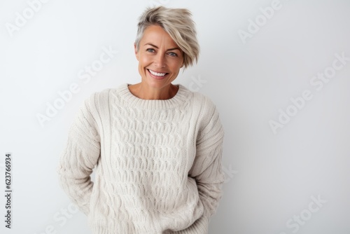 Portrait of happy mature woman standing with arms crossed against white background