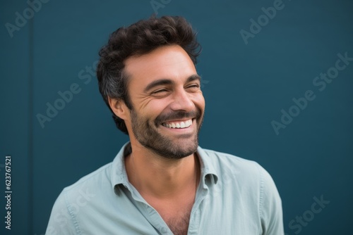 Portrait of smiling man standing against blue wall in the street.