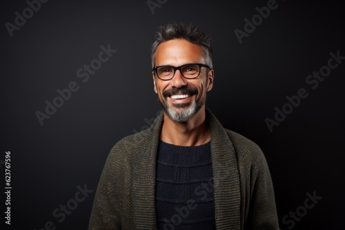 Portrait of a smiling man in glasses looking at camera isolated on black background