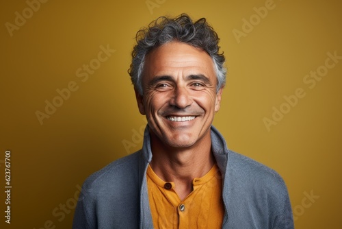 Portrait of a smiling middle-aged man on a yellow background