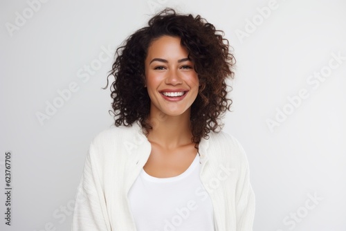 Portrait of a smiling young woman looking at camera over white background