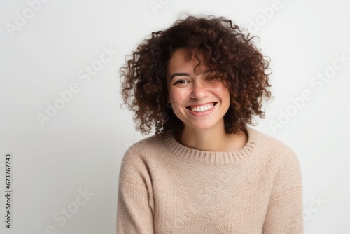 Portrait of a smiling young woman with curly hair against white background