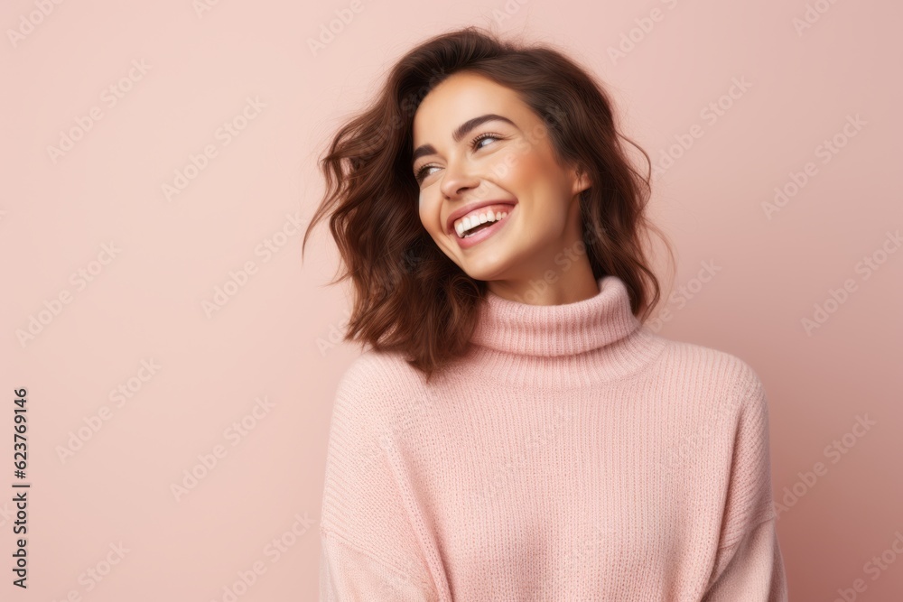Portrait of a smiling young woman in pink sweater over pink background Portrait of a smiling young woman in pink sweater over pink background