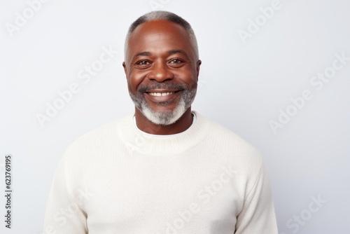 Portrait of a smiling mature African-American man standing against white background