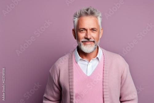 Portrait of a senior man with grey hair. Isolated on purple background. © Anne Schaum