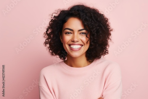 Portrait of a beautiful young african american woman smiling against pink background