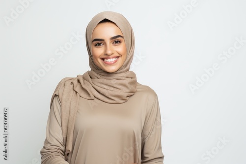 portrait of smiling young muslim woman in hijab looking at camera