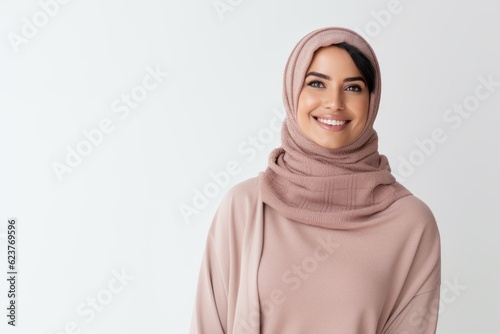 cheerful young muslim woman in hijab looking at camera isolated on white