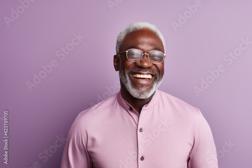 Portrait of happy african american senior man in eyeglasses looking at camera and smiling © Anne Schaum