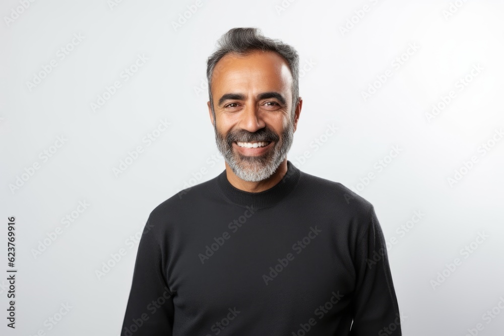Portrait of a smiling middle-aged Indian man standing against white background Portrait of a smiling middle-aged Indian man standing against white background