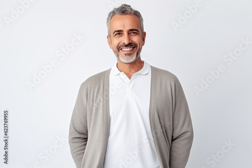 Portrait of handsome mature man looking at camera and smiling while standing against white background