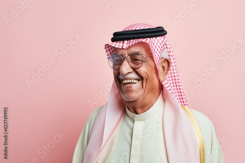 Portrait of an old arabic man smiling against pink background