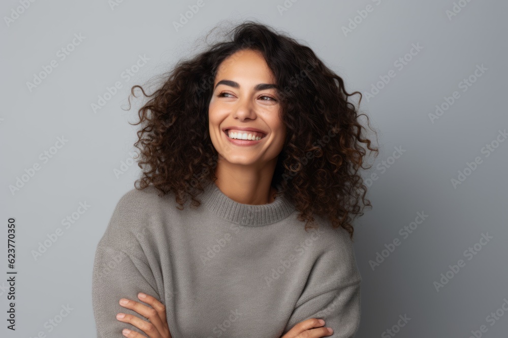 Portrait of a smiling young woman with curly hair isolated on gray background Portrait of a smiling young woman with curly hair isolated on gray background