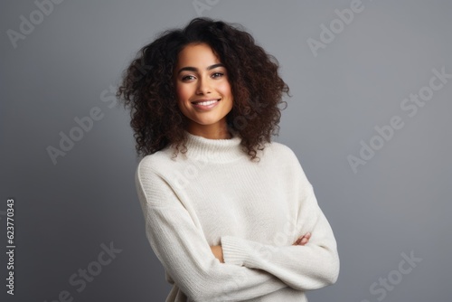 Portrait of a smiling young african american woman standing against grey background