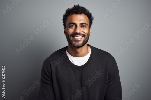 Portrait of a handsome african american man smiling at camera while standing against grey background