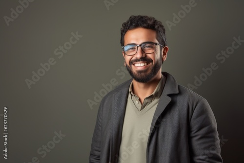 Portrait of a happy young man in eyeglasses on grey background