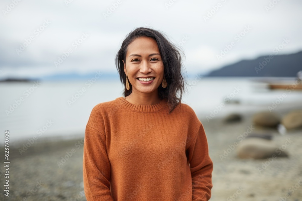 Portrait of a smiling young woman standing on the beach in autumn Portrait of a smiling young woman standing on the beach in autumn