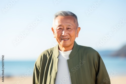 Portrait of happy senior man standing on beach on a sunny day