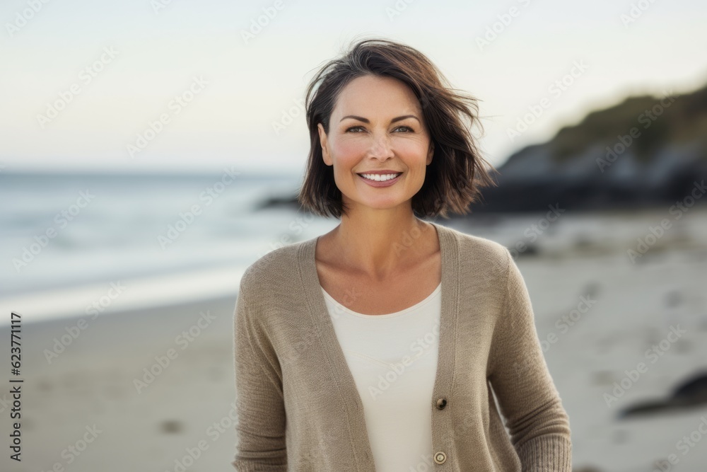 Portrait of smiling mid adult woman standing on beach at the day time Portrait of smiling mid adult woman standing on beach at the day time