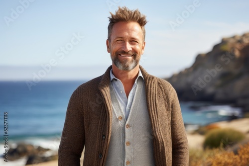 Portrait of a handsome man smiling at the camera on the beach