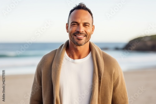 Portrait of handsome man with coat on the beach at the day time © Robert MEYNER