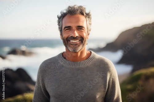 Portrait of smiling man standing in front of the camera at the beach