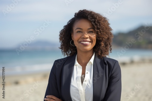 Portrait of a smiling businesswoman standing with arms crossed on the beach