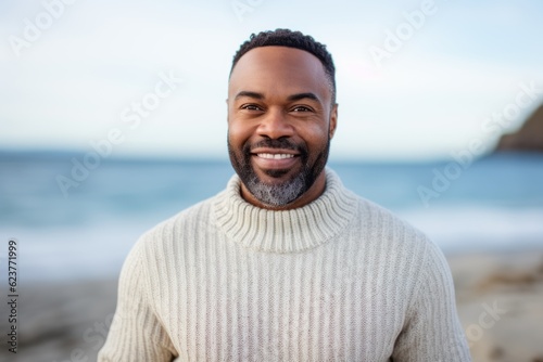 Portrait of smiling man standing on beach with ocean in the background © Robert MEYNER