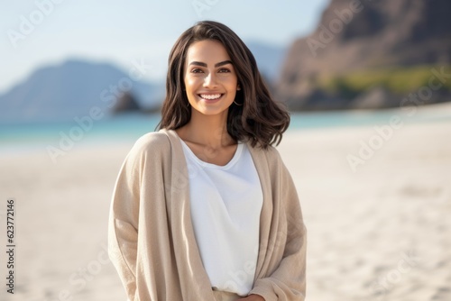 beautiful smiling young woman in beige poncho on beach