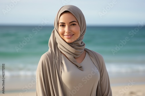 Portrait of beautiful young muslim woman wearing hijab on the beach