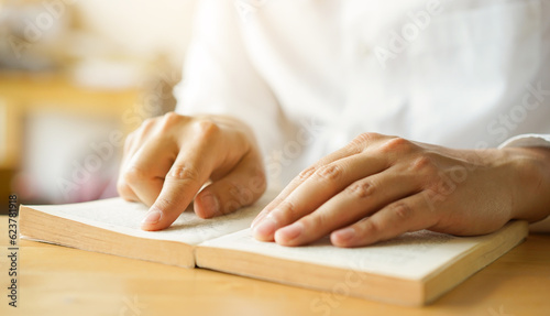 close up young man hand open bible book and reading sentence and worship in the church for hope an religion of christian concept photo