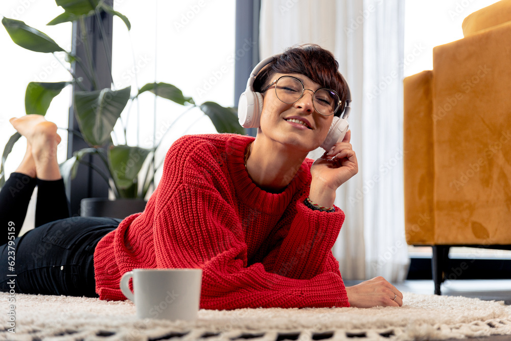 © leszekglasner - Relaxing at home listening music on headphones lying on floor © leszekglasner - Relaxing at home listening music on headphones lying on floor