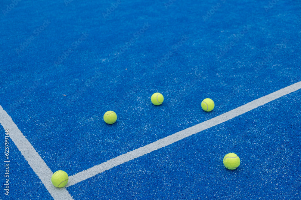 selective focus , centre line of a blue paddle tennis court with five balls